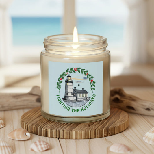 Candle in a jar with a lighthouse label on a wooden coaster surrounded by string lights and a guitar in the background.