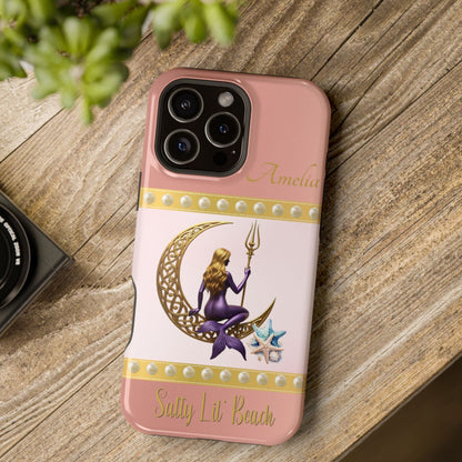 Phone case with a design of a mermaid and crescent moon on a pink background, placed on a wooden surface.