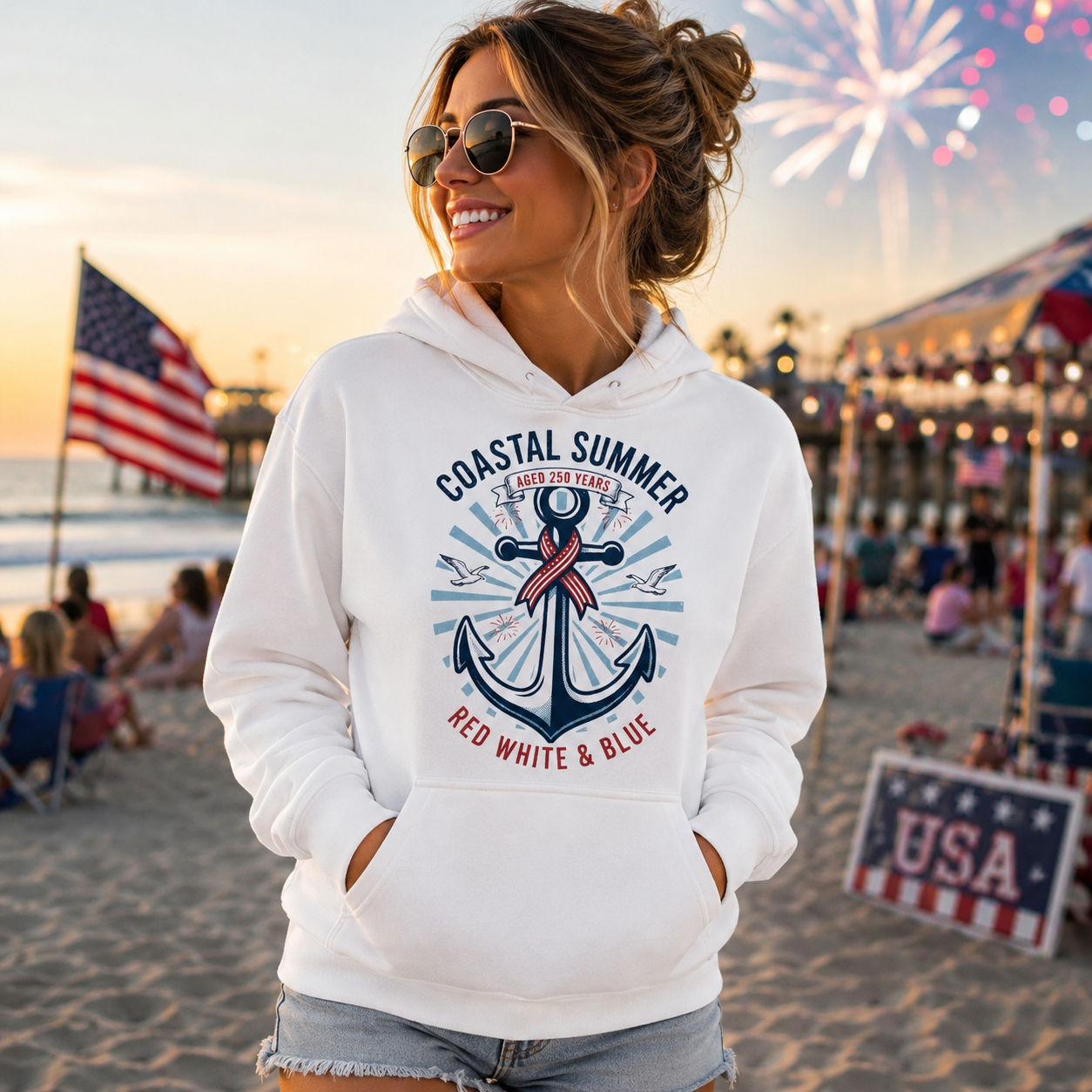 Woman wearing a white hoodie with an anchor design on a beach with fireworks in the background
