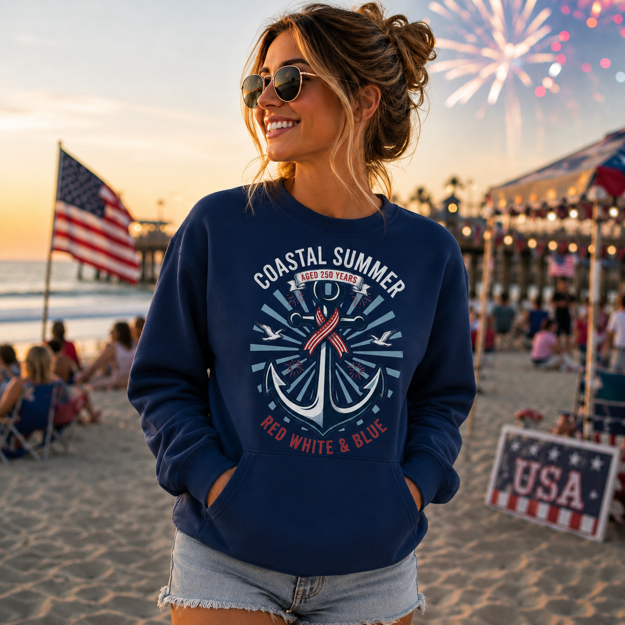 Woman wearing a navy blue sweatshirt with an anchor design on a beach with fireworks in the background.
