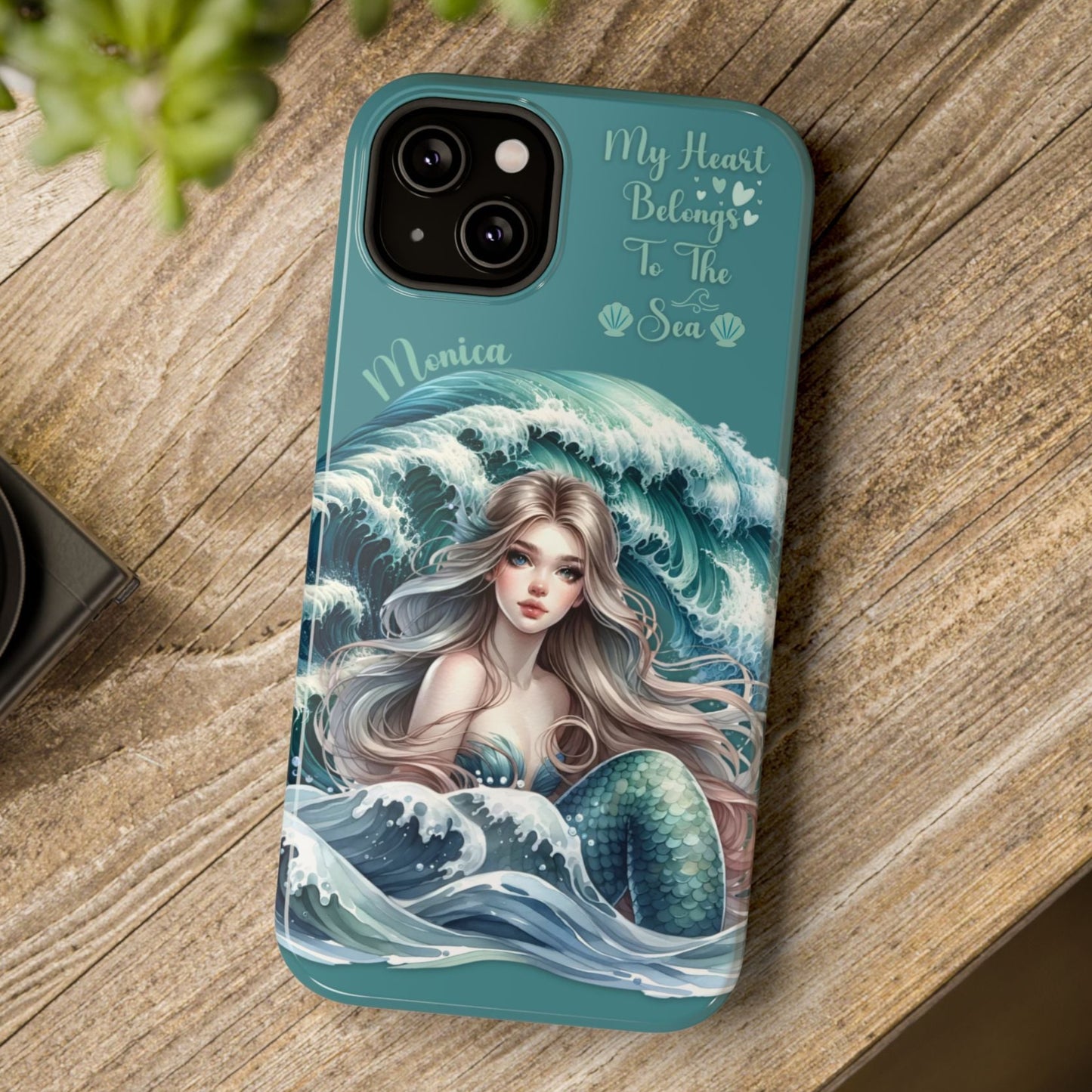 Phone case with mermaid design on a wooden surface