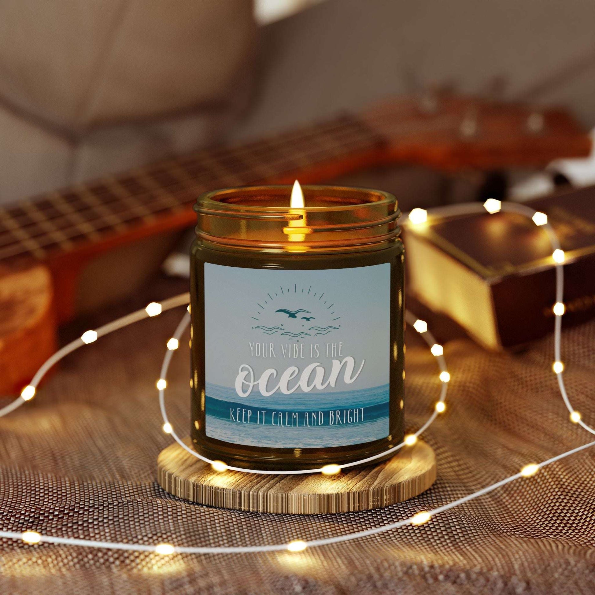 Candle in an amber jar with a label with an ocean scene and text 'Your vibe is the Ocean Keep it Calm and Bright'.
