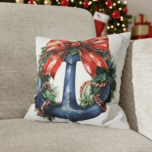 Decorative pillow with a Christmas design featuring a blue anchor with a red bow on a  couch.