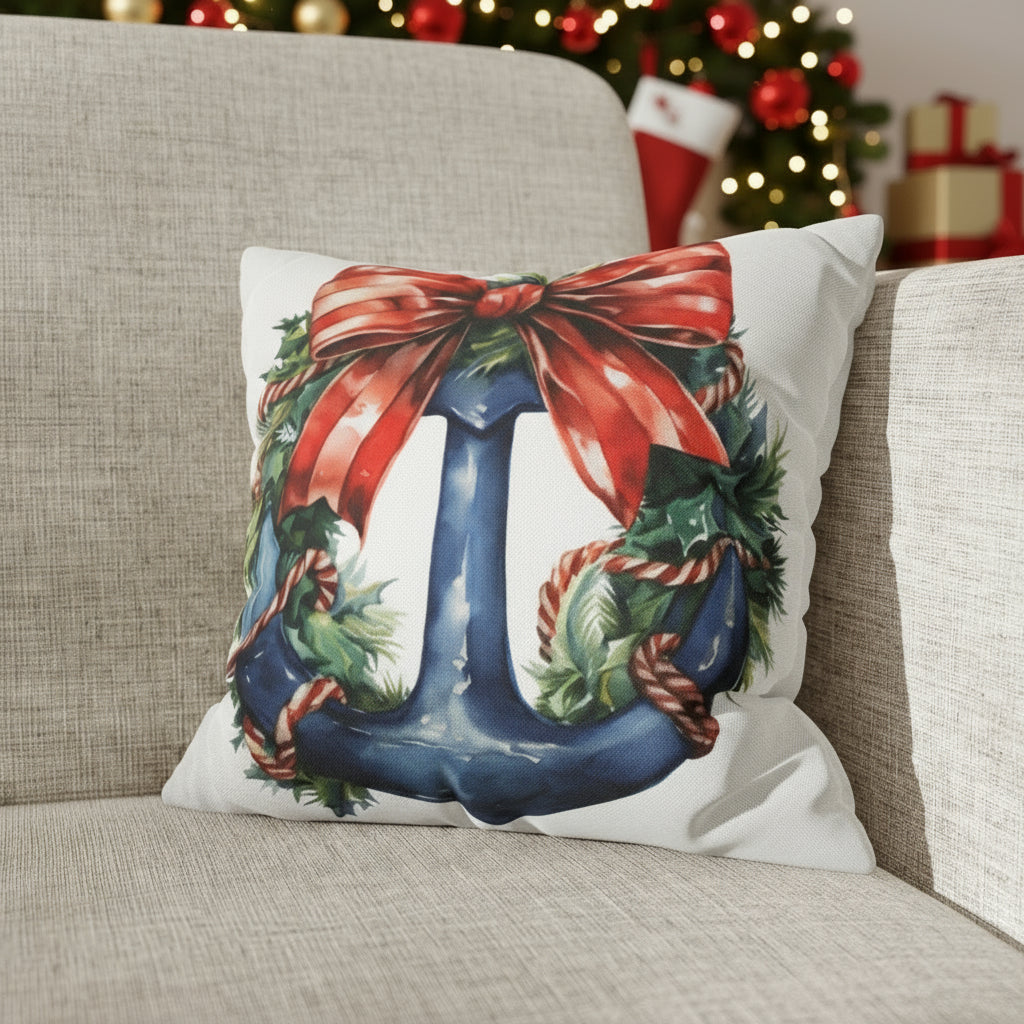 Decorative pillow with a Christmas design featuring a blue anchor with a red bow on a  couch.