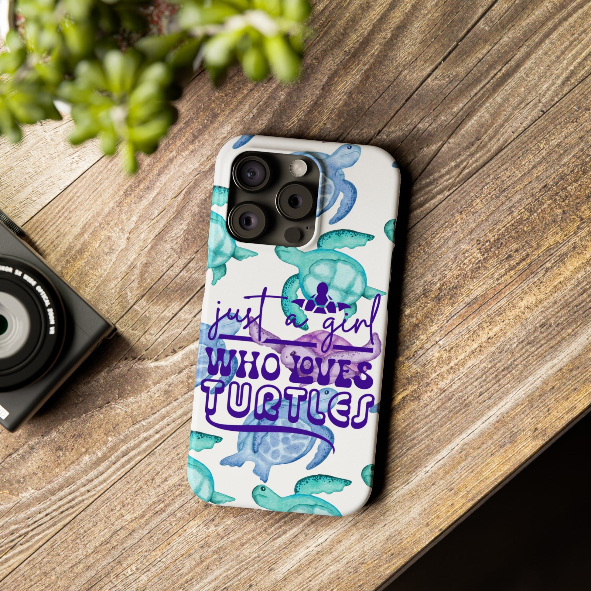 Iphone case with turquoise, blue and purple sea turtles that says  Just a Girl Who Loves Sea turtles laying on wood table