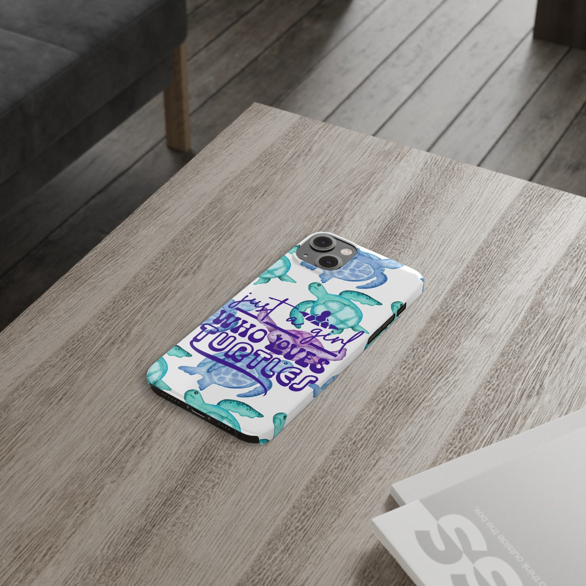 Iphone case with turquoise, blue and purple sea turtles that says  Just a Girl Who Loves Sea turtles laying on table