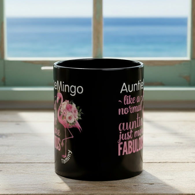 Black mug with pink flamingo and text design on a white background