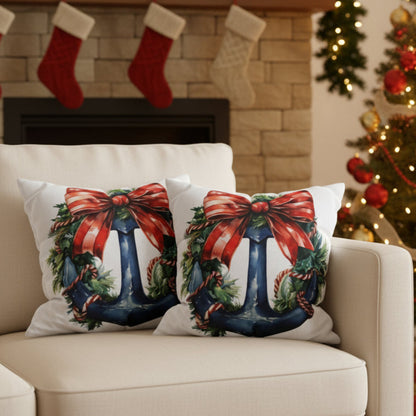 Two Christmas-themed pillows with a blue anchor and a red bow on a  sofa.