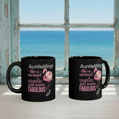 Two black mugs with flamingo design and text on a desk.