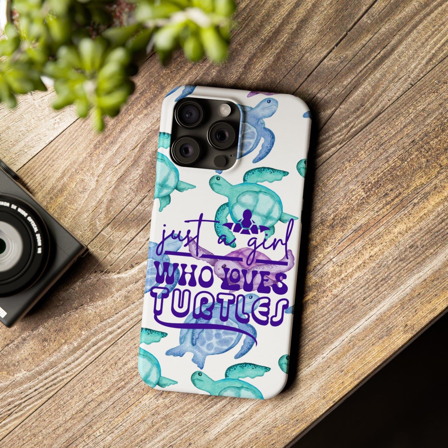 Iphone case with turquoise, blue and purple sea turtles that says  Just a Girl Who Loves Sea turtles laying on wood table