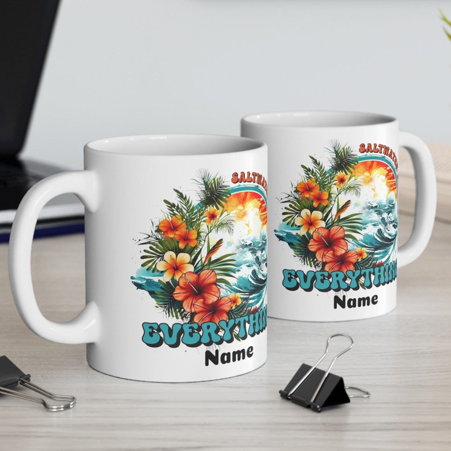 2 10 oz. White ceramic mugs with an ocean scene surrounded by tropical flowers with the text Saltwater Heals Everything and the word Name underneath where it can be personalized.