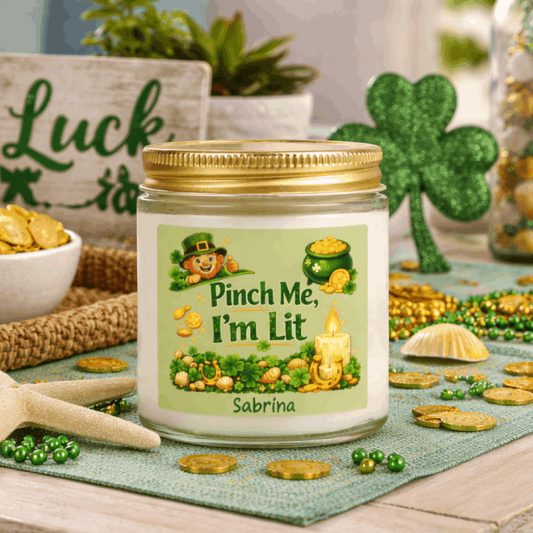 Clear candle jar with a lit candle, green label, and gold lid on with St. Patrick's Day Design and text Pinch Me, I'm Lit that can be personalized.