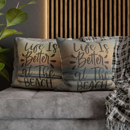 Two pillow cases with 'Life is Better at the Beach' text on a couch.
