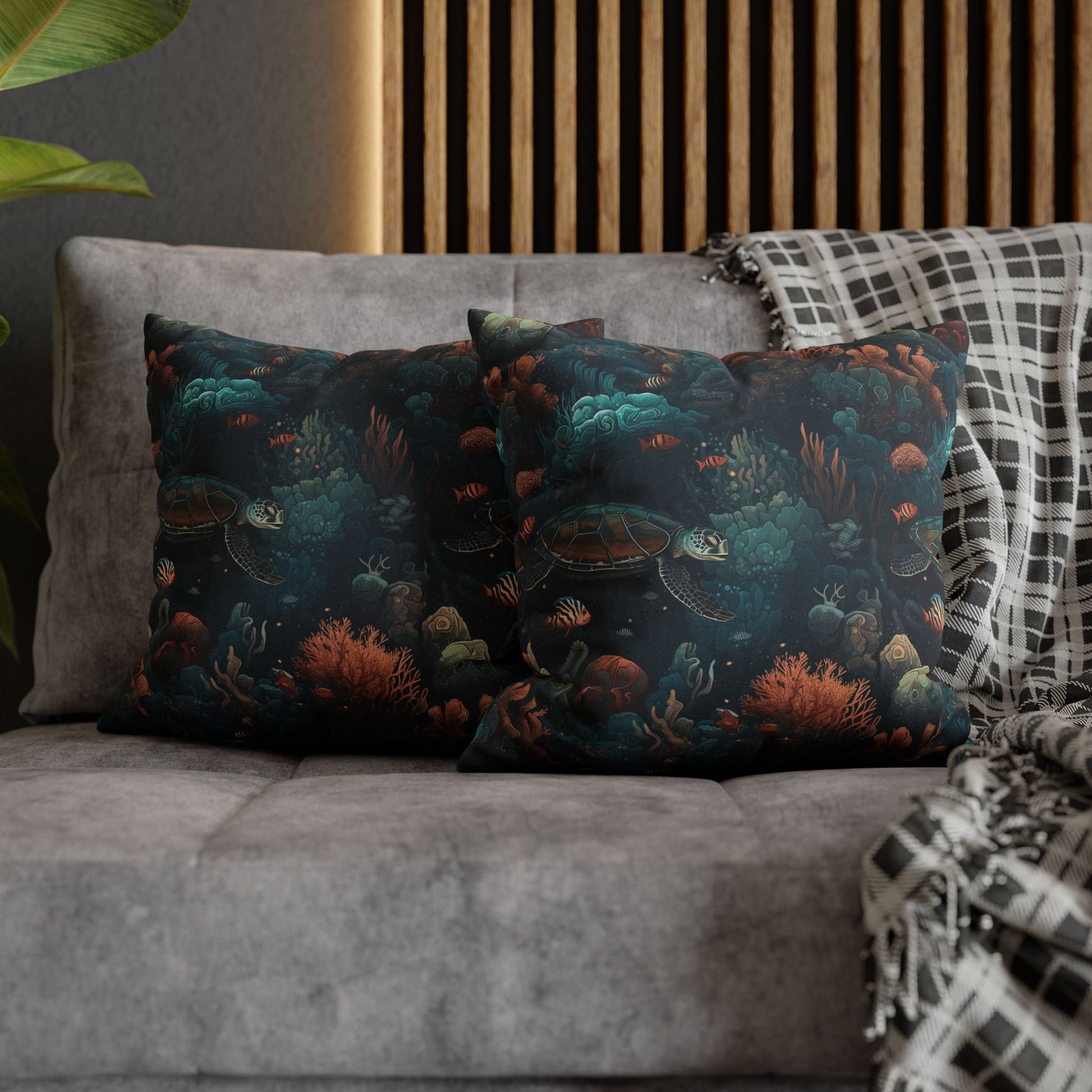 16" x 16" two decorative pillows with underwater scene with sea turtles on a gray couch.