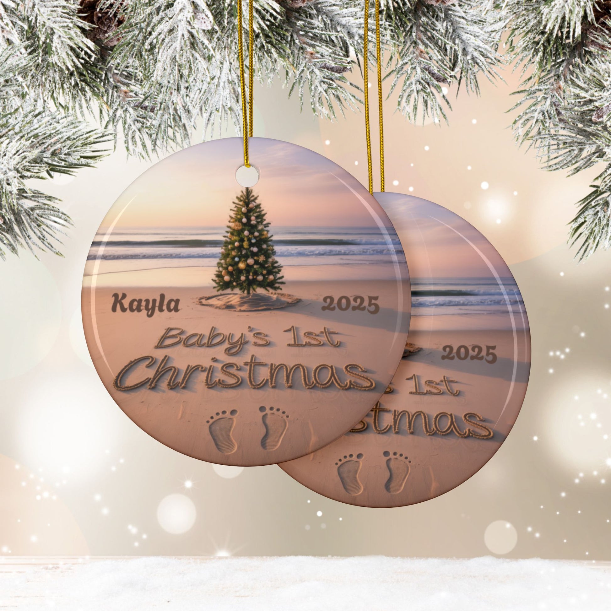 Round Christmas ornament with beach scene and 'Baby's 1st Christmas' text, hanging against a snowy background.