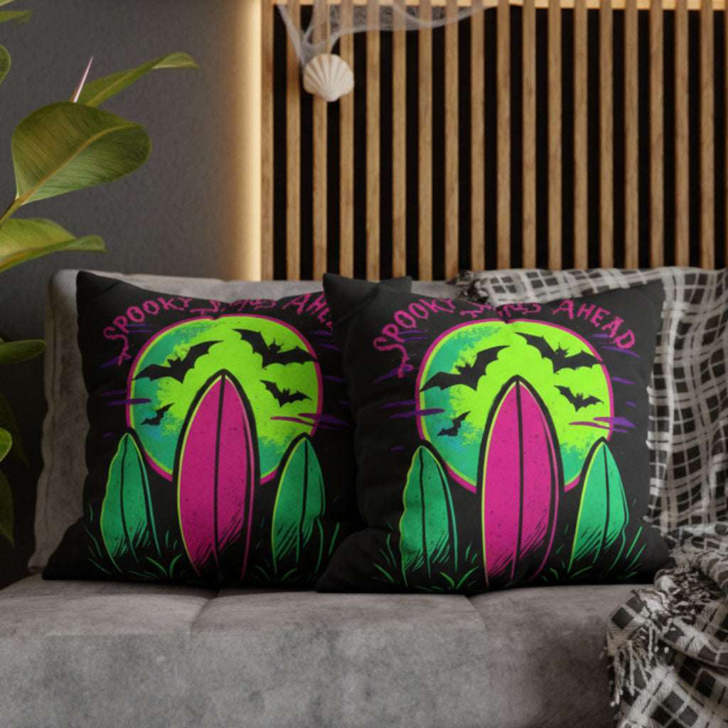 Decorative pillow cases with Halloween-themed surf design with text Spooky Shores Ahead on a couch.