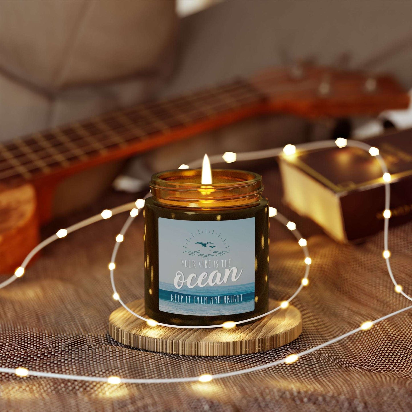 Candle in an amber jar with a label with an ocean scene and text 'Your vibe is the Ocean Keep it Calm and Bright'.