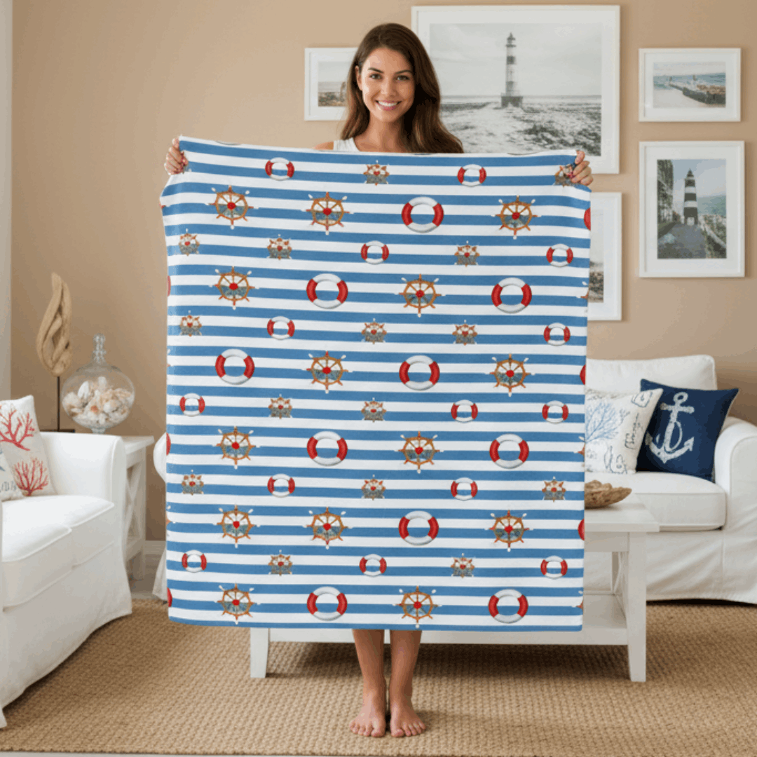 Woman holding a blue and white striped blanket with nautical patterns in a living room.