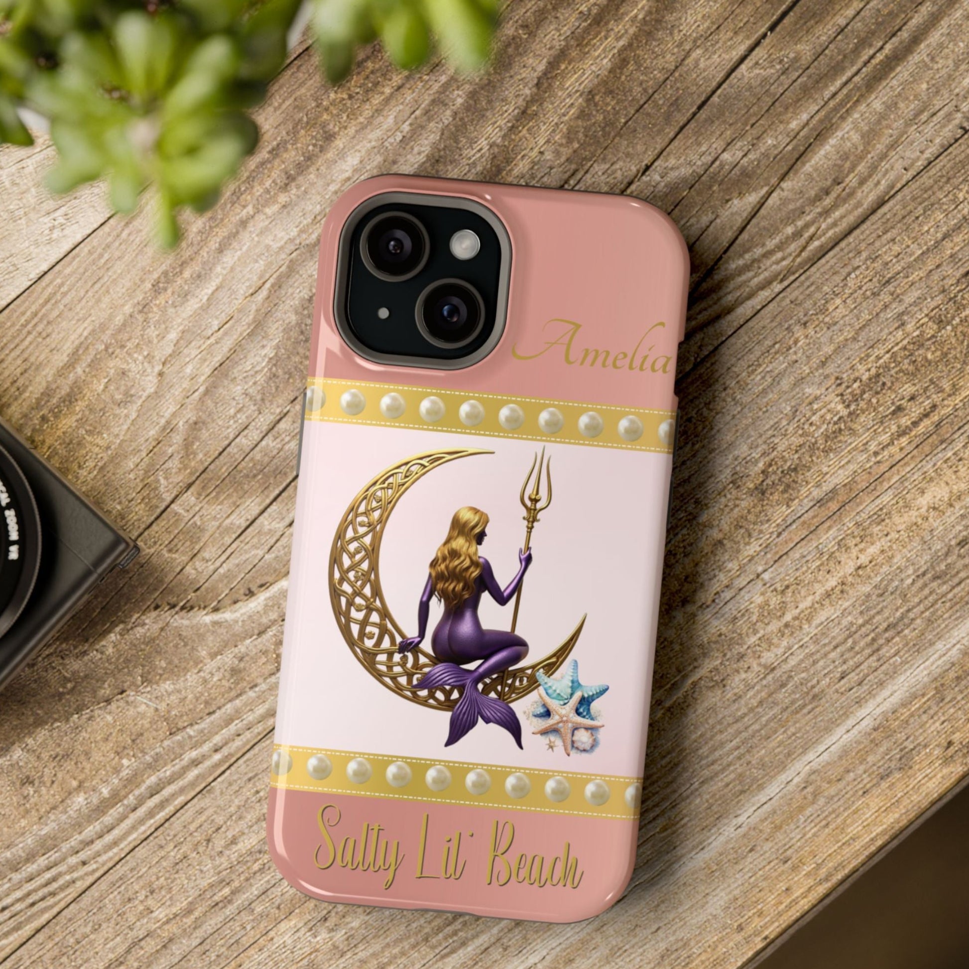 Phone case with a design of a mermaid and moon on a pink background.