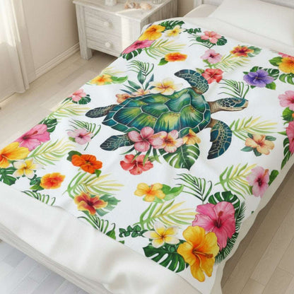 Cozy tropical velveteen 50x60 throw blanket featuring a sea turtle surrounded by colorful hibiscus flowers and palm leaves, perfect for beachy home decor.
