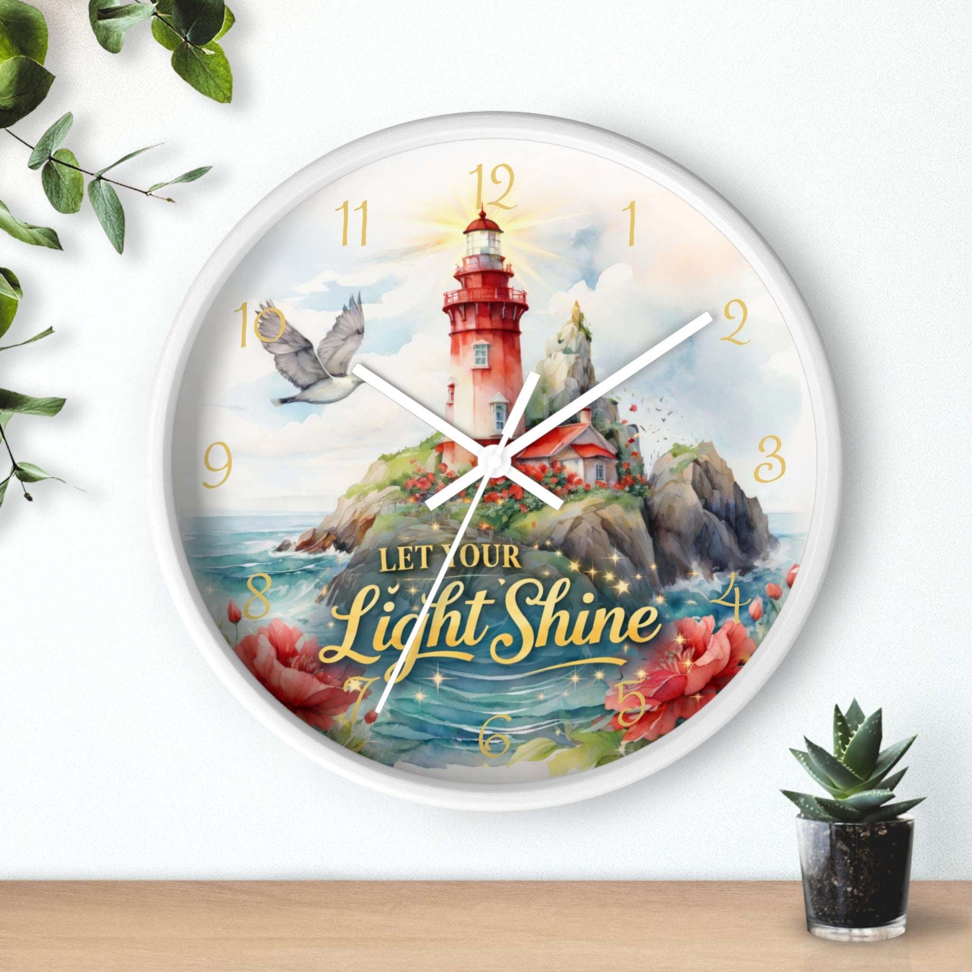 Decorative wall clock with a lighthouse design and 'Let Our Light Shine' text, placed on a surface with decorative items.