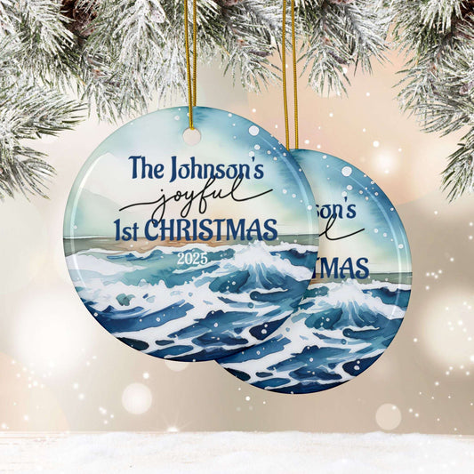 Round Christmas ornament with ocean design and personalized text 'The Johnson's joyful 1st CHRISTMAS 2025' against a snowy background.