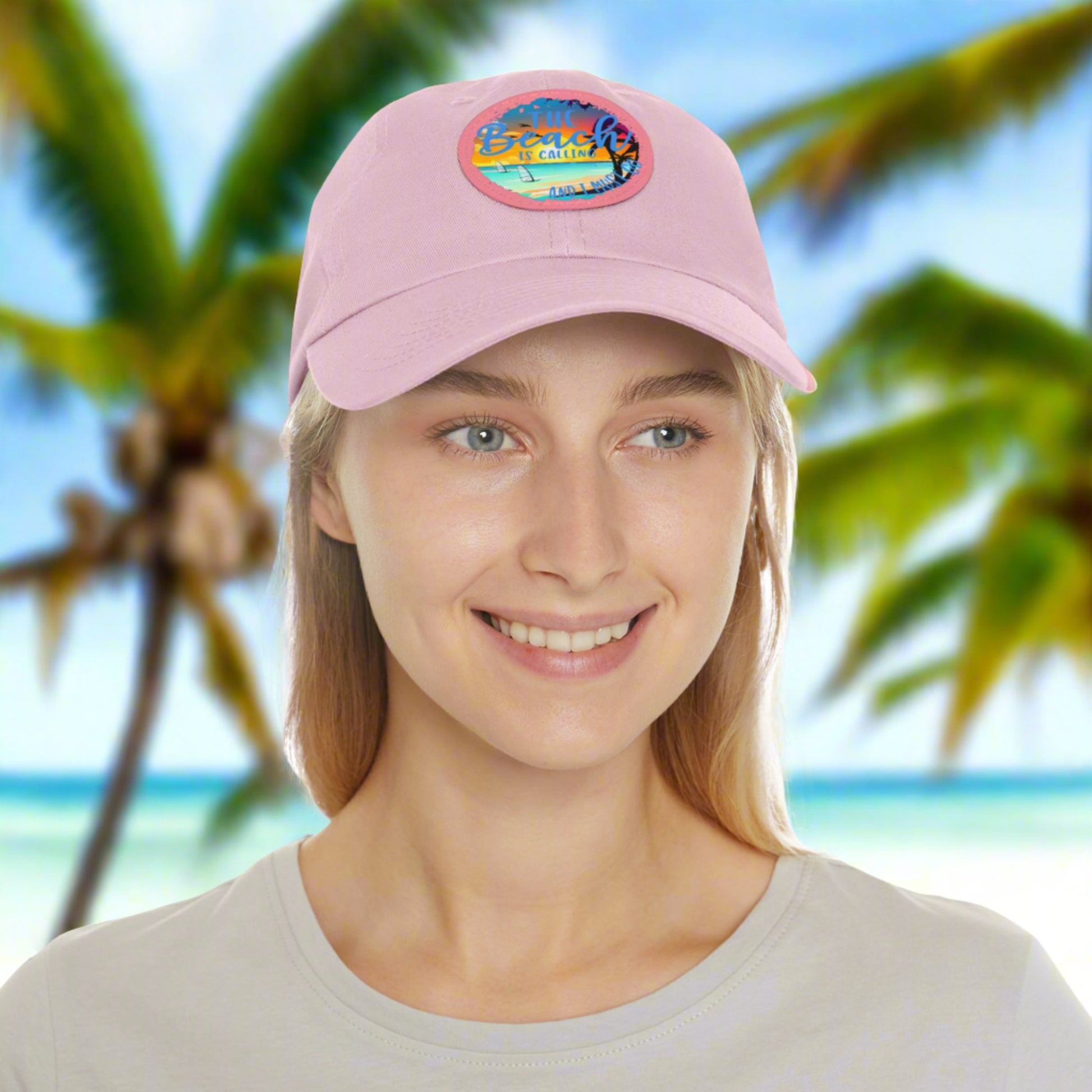 Pink hat with a leather patch with picture of beach scene and text The beach is calling and I must go.