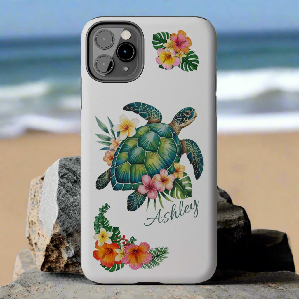 iPhone 13 case with a white background and a sea turtle with hibiscus flowers, with more hibiscus flowers around the sides.