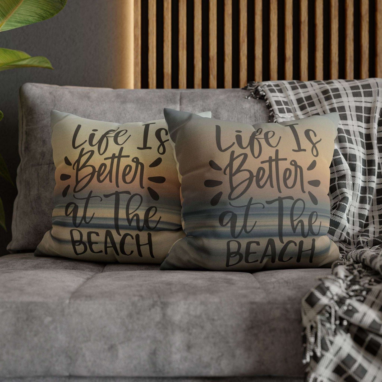 Pillow cases with 'Life is better at the beach' text on a couch.