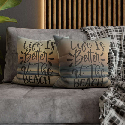 Pillow cases with 'Life is better at the beach' text on a couch.