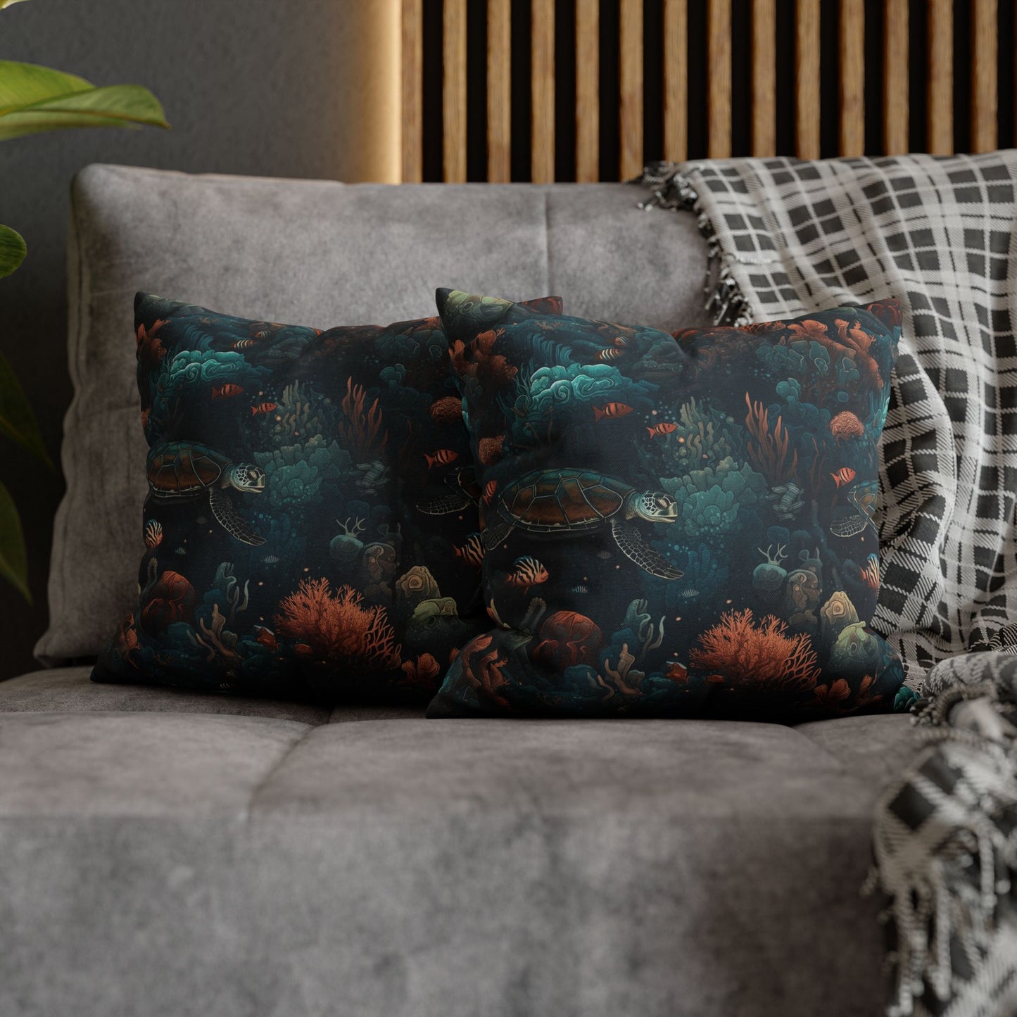 14" x 14" two decorative pillows with underwater scene with sea turtles on a gray couch.