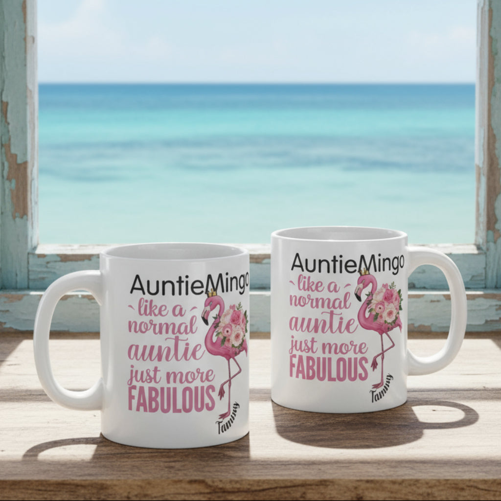 Two mugs with flamingo designs and text on a desk with office items.