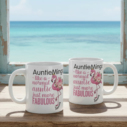 Two mugs with flamingo designs and text on a desk with office items.