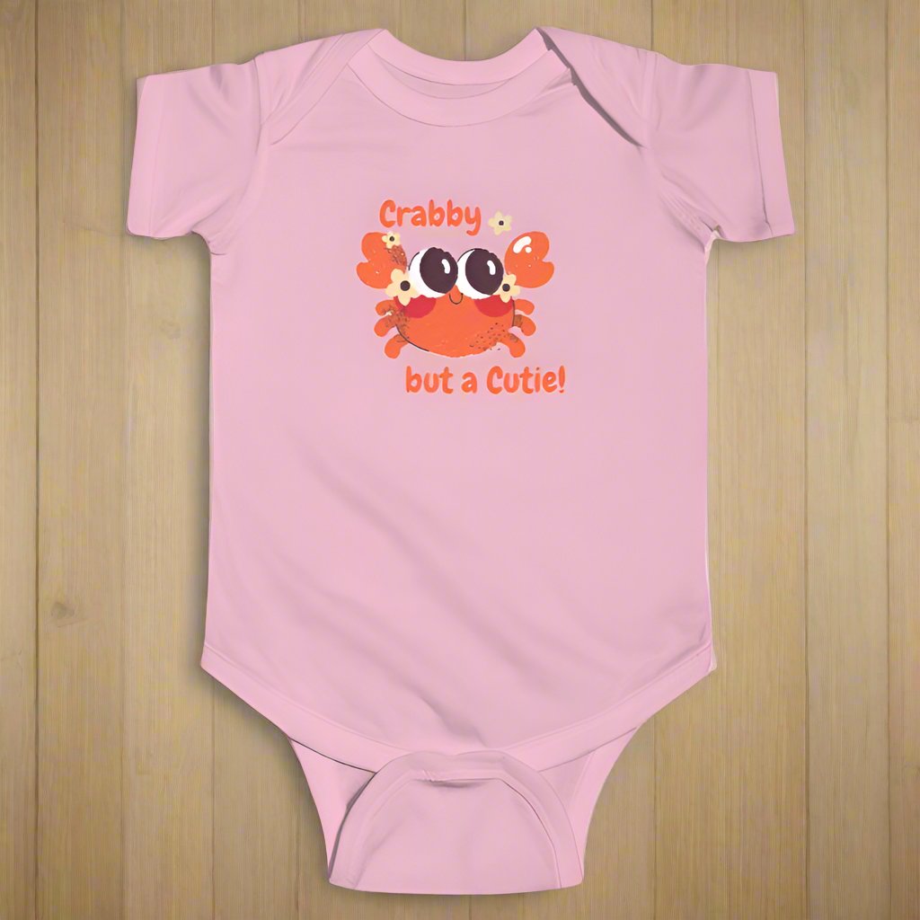 Light Pink short sleeved body suit with cartoon crab that says crabby but a cutie