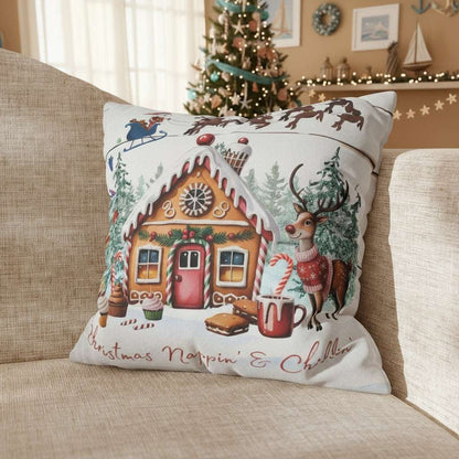 Decorative Christmas pillow with gingerbread house and reindeer on a couch.
