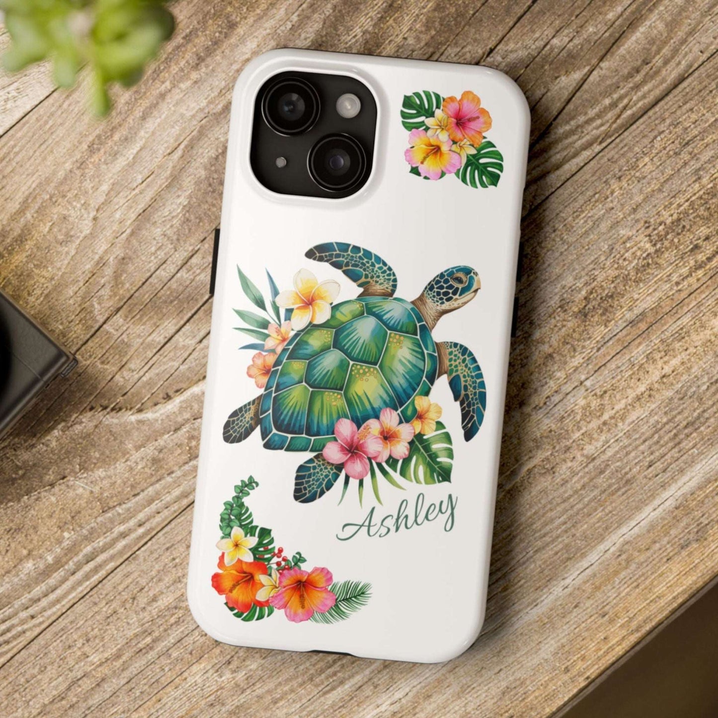 iPhone 15 case with a white background and a sea turtle with hibiscus flowers, with more hibiscus flowers around the sides.