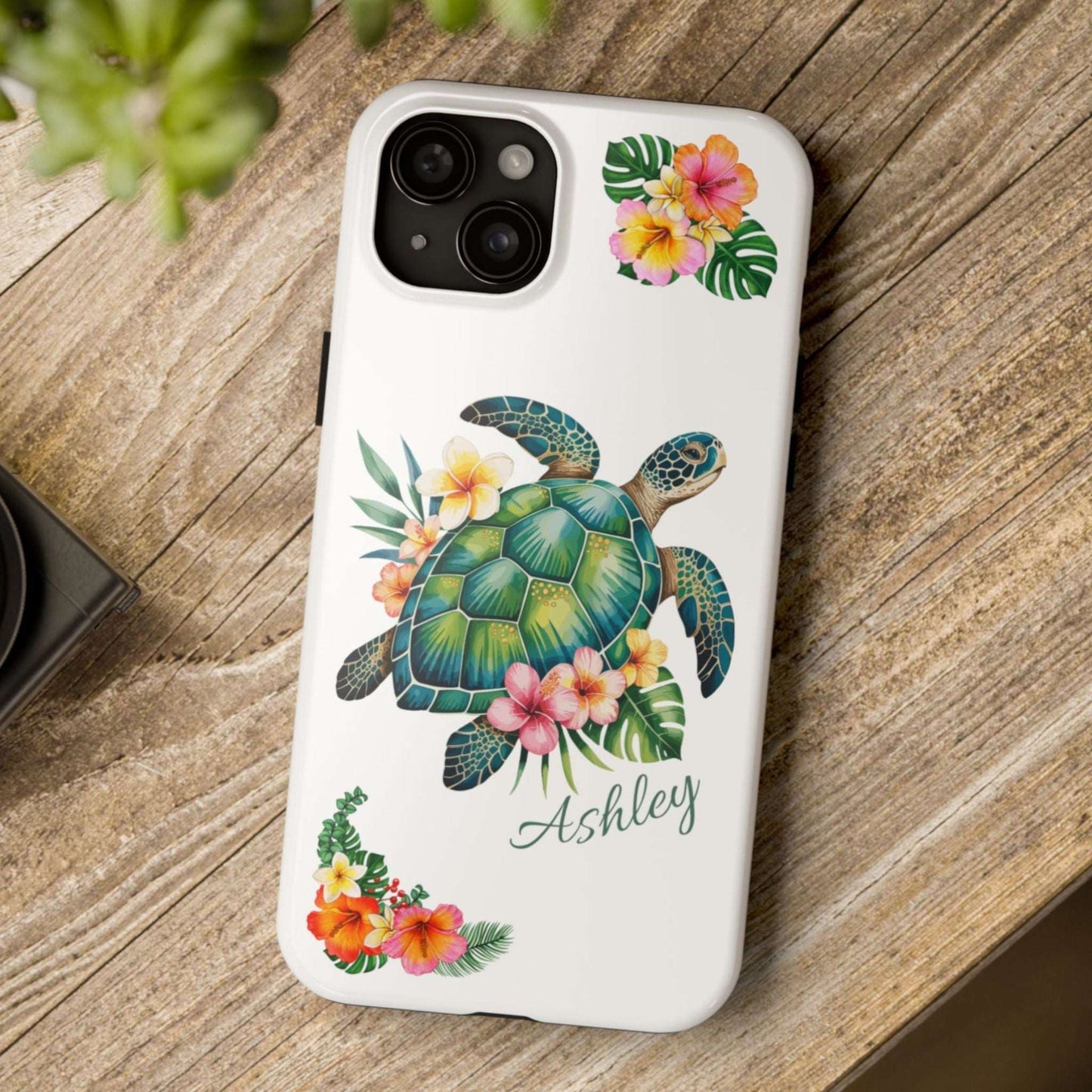 iPhone 15 case with a white background and a sea turtle with hibiscus flowers, with more hibiscus flowers around the sides.