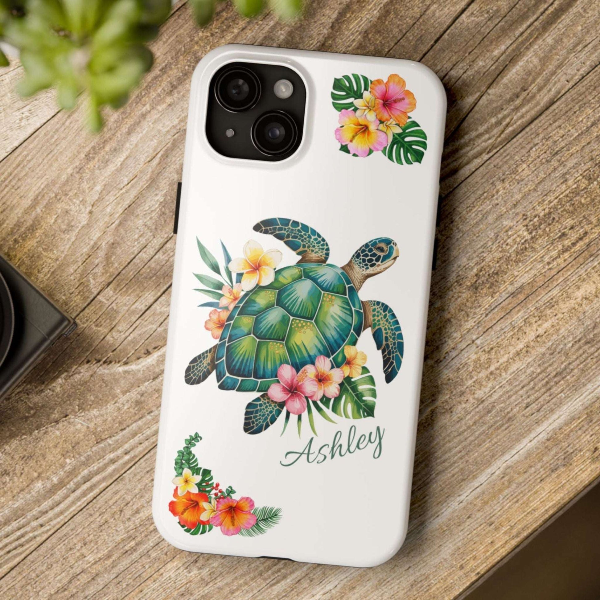iPhone 15 case with a white background and a sea turtle with hibiscus flowers, with more hibiscus flowers around the sides.