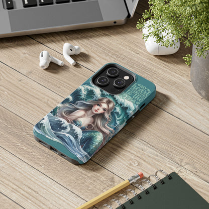 Phone Case with Flowy mermaid with ocean wave behind and text My Heart Belongs to the Sea laying on desk.