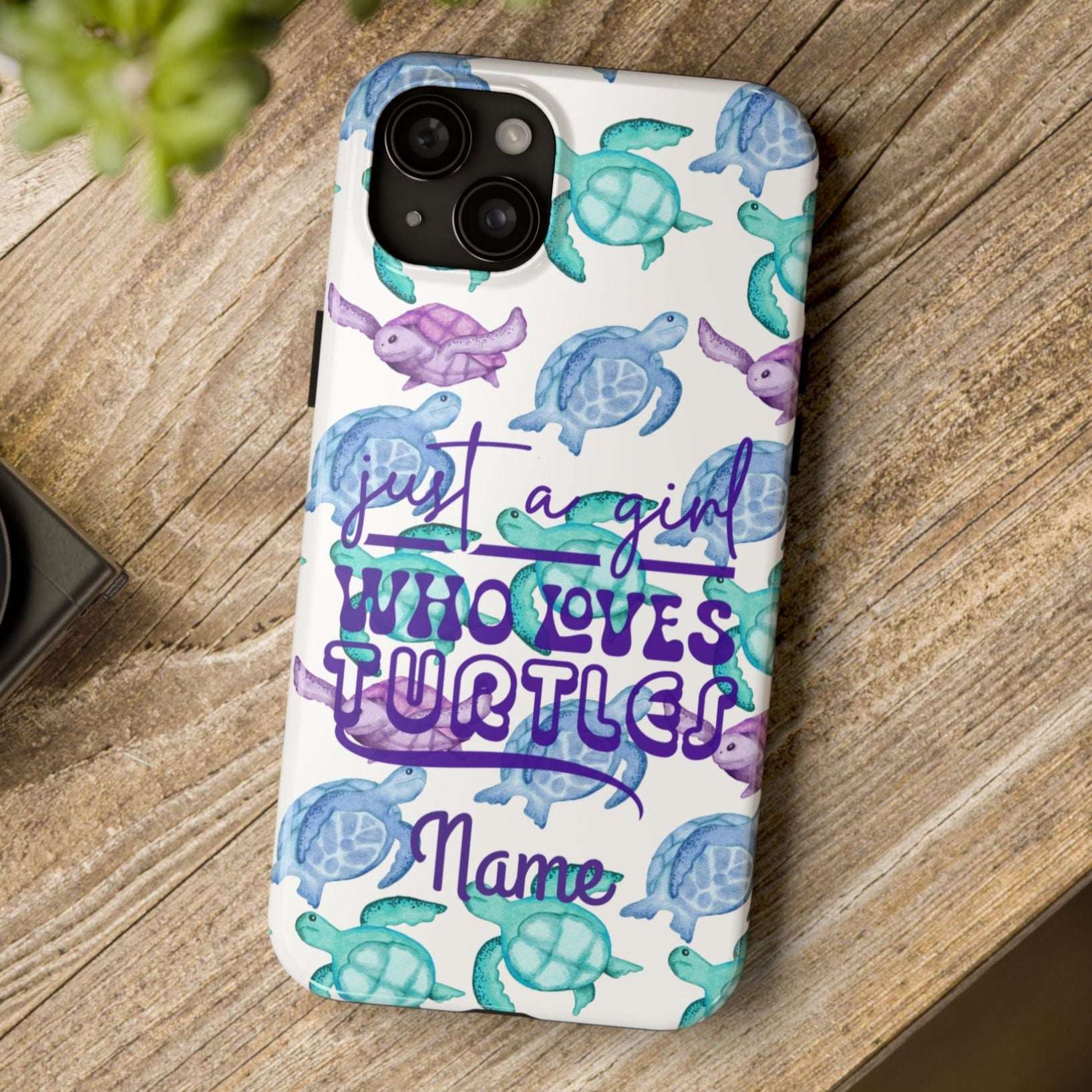 Phone case with sea turtle design and text on a wooden surface