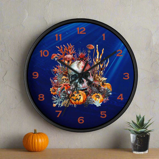 Wall clock with Halloween-themed design featuring a skull, pumpkins, and foliage on a blue background.