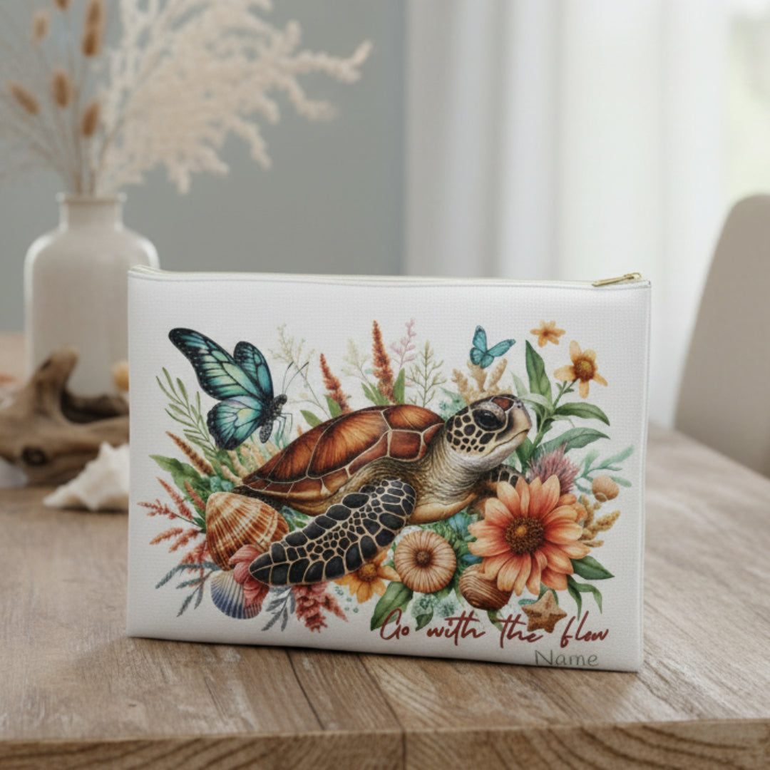 Pouch with a turtle, butterfly, and floral design on a white background