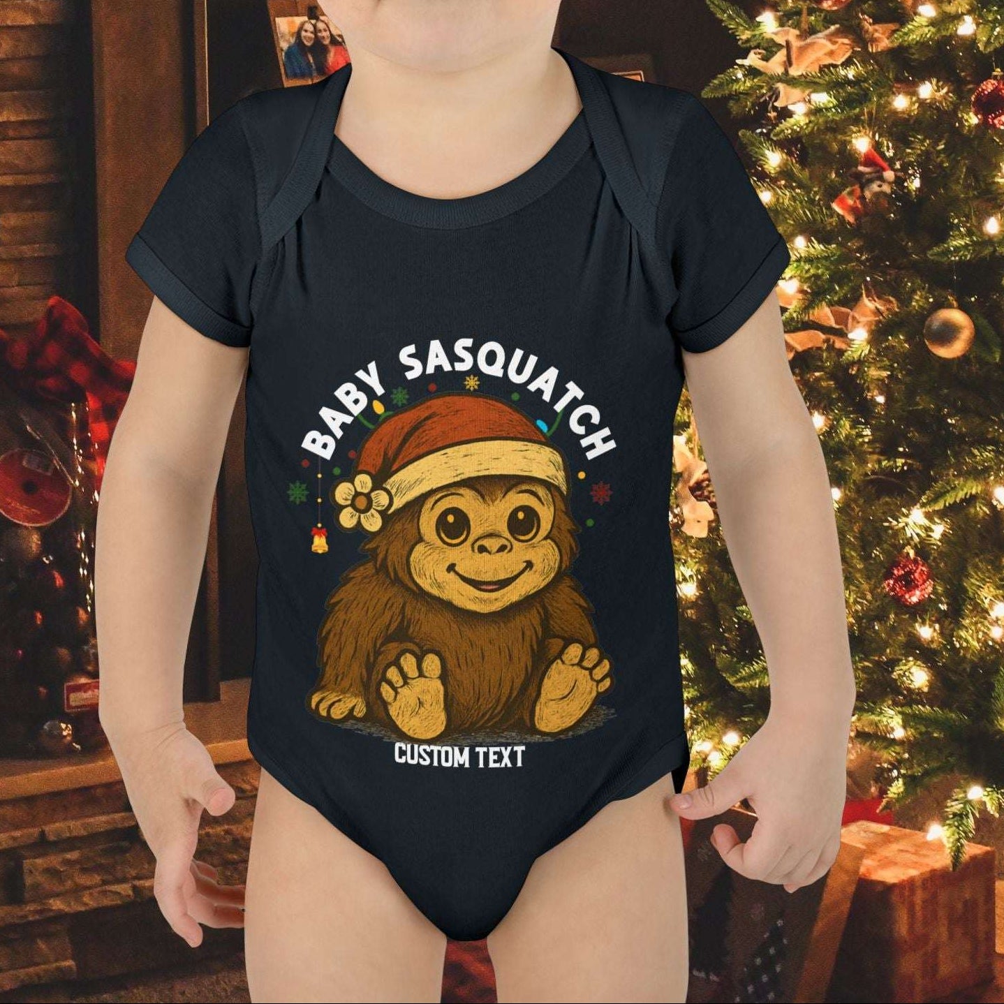 Child wearing a 'Baby Sasquatch' onesie with custom text.