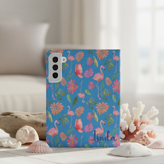 Flip phone case with flamingo and floral design on a blue background and personalized with name.