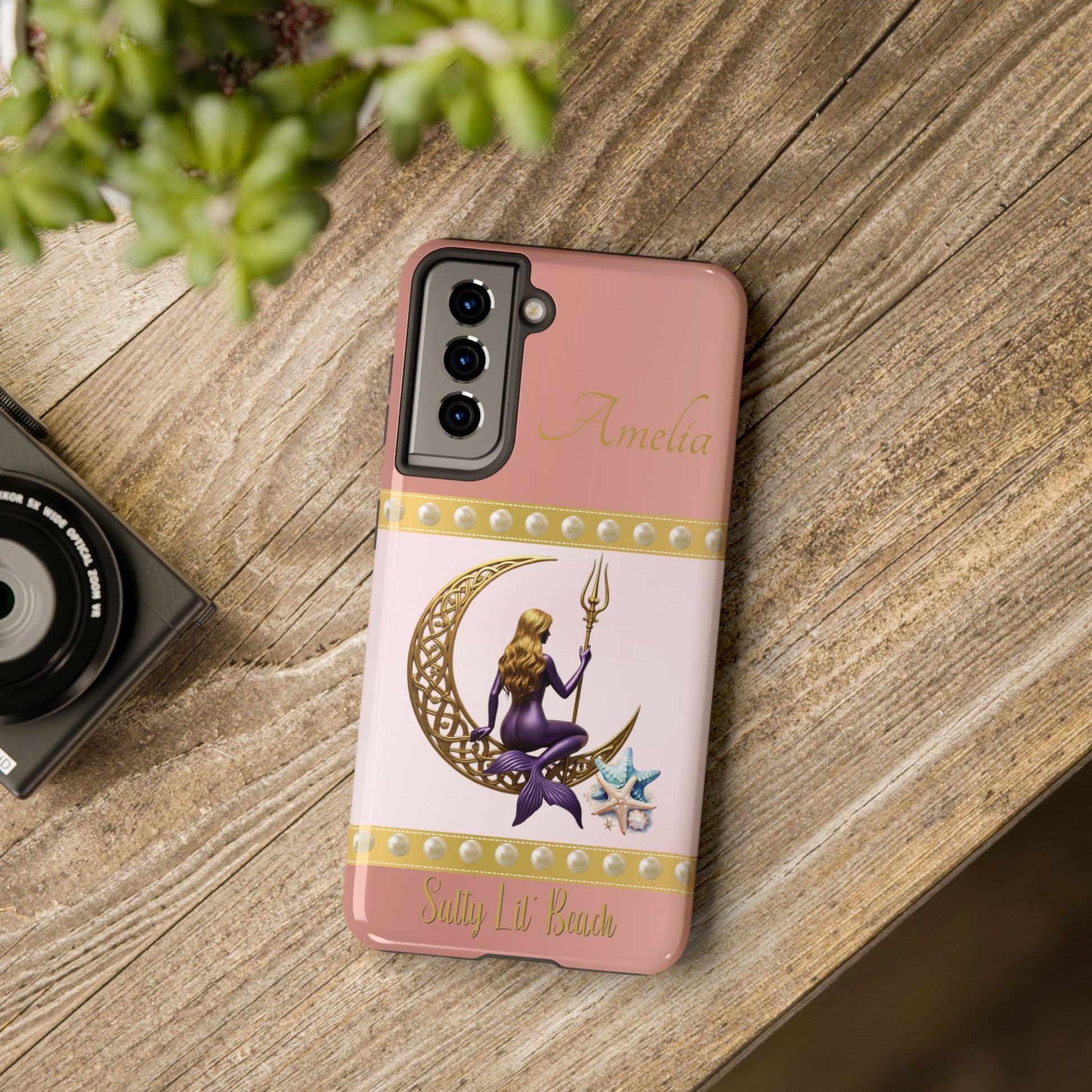 Phone case with mermaid design on a wooden surface