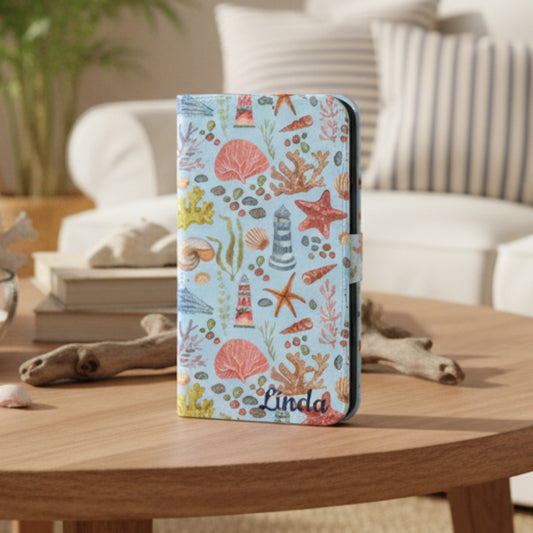 Flip phone case with a watercolor pattern featuring lighthouses, seashells, coral, and starfish, customizable with a name.