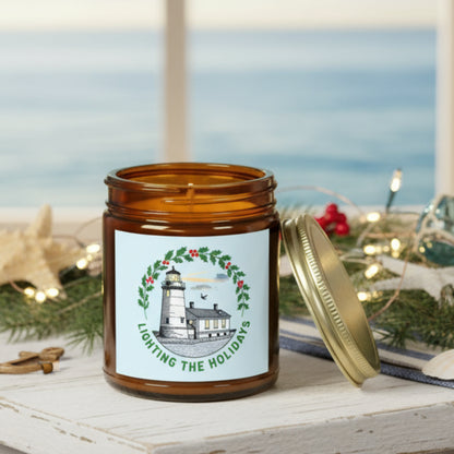 Candle in an amber jar with a decorative label featuring a lighthouse and holly wreath on a white background.