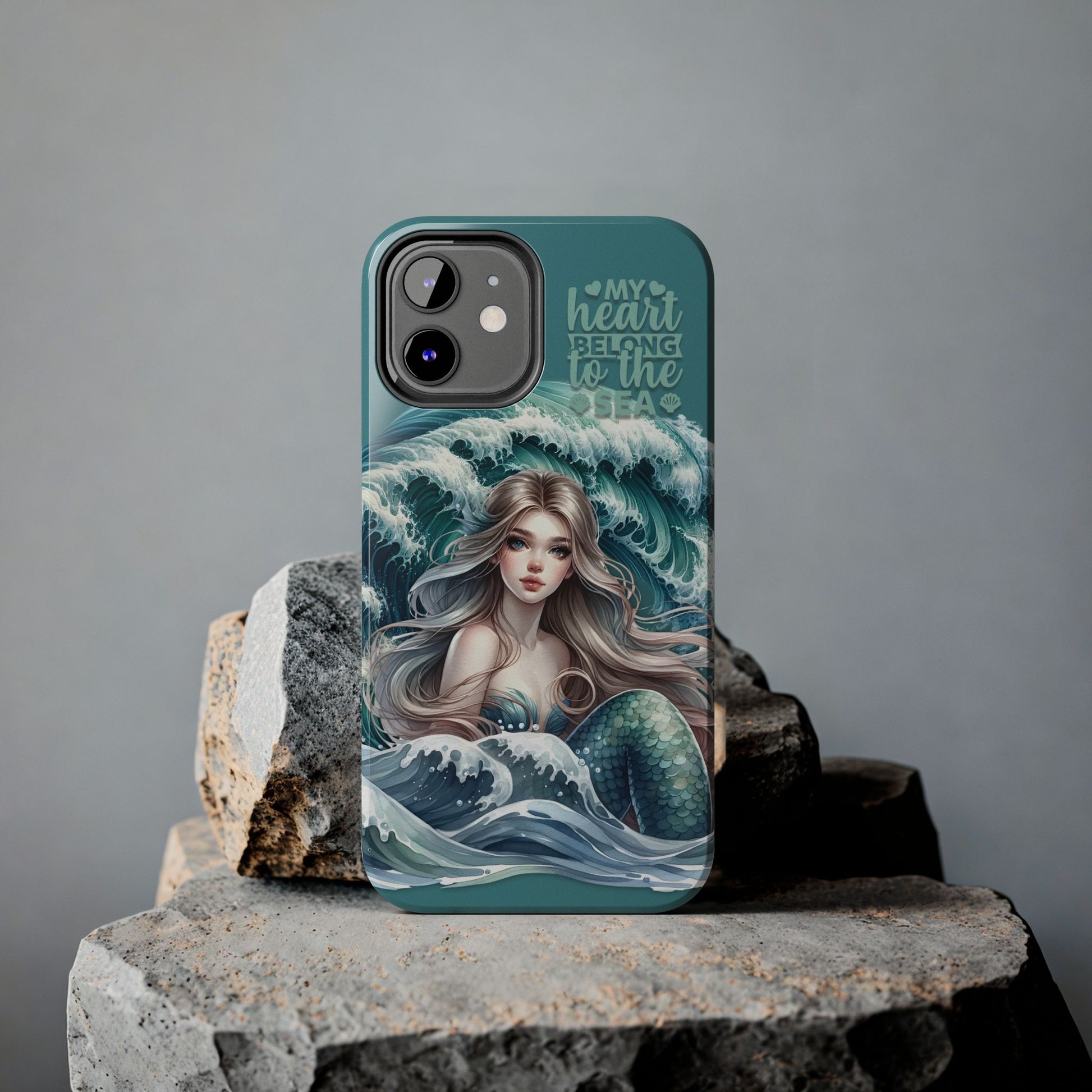 Phone Case with Flowy mermaid with ocean wave behind and text My Heart Belongs to the Sea against rock