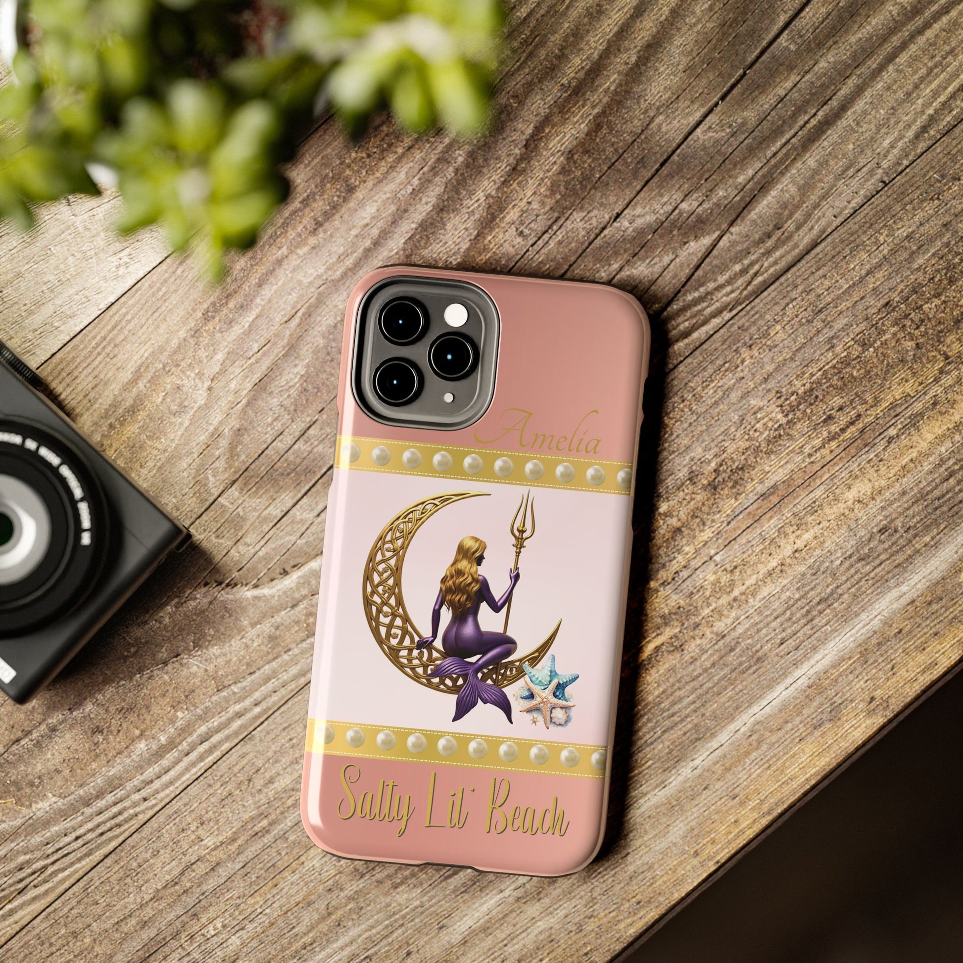 Phone case with mermaid design on a wooden surface
