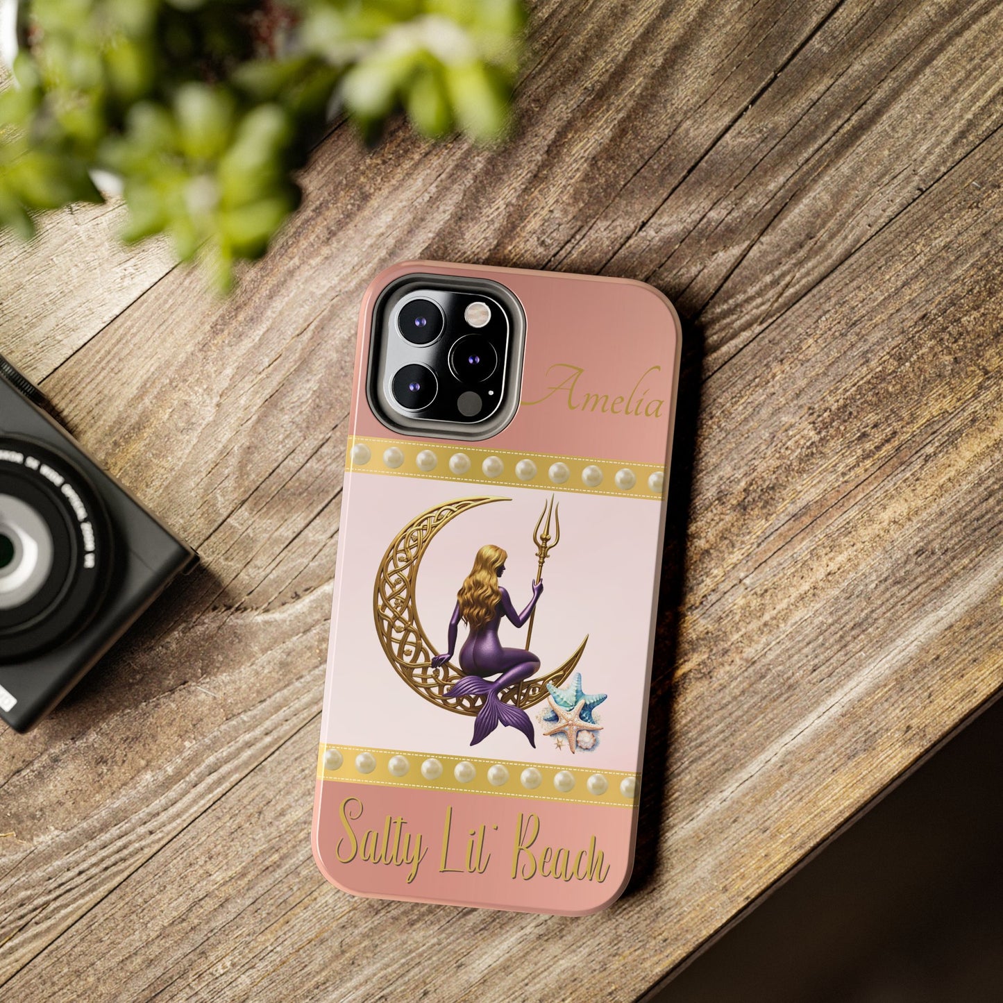Phone case with mermaid design on a wooden surface